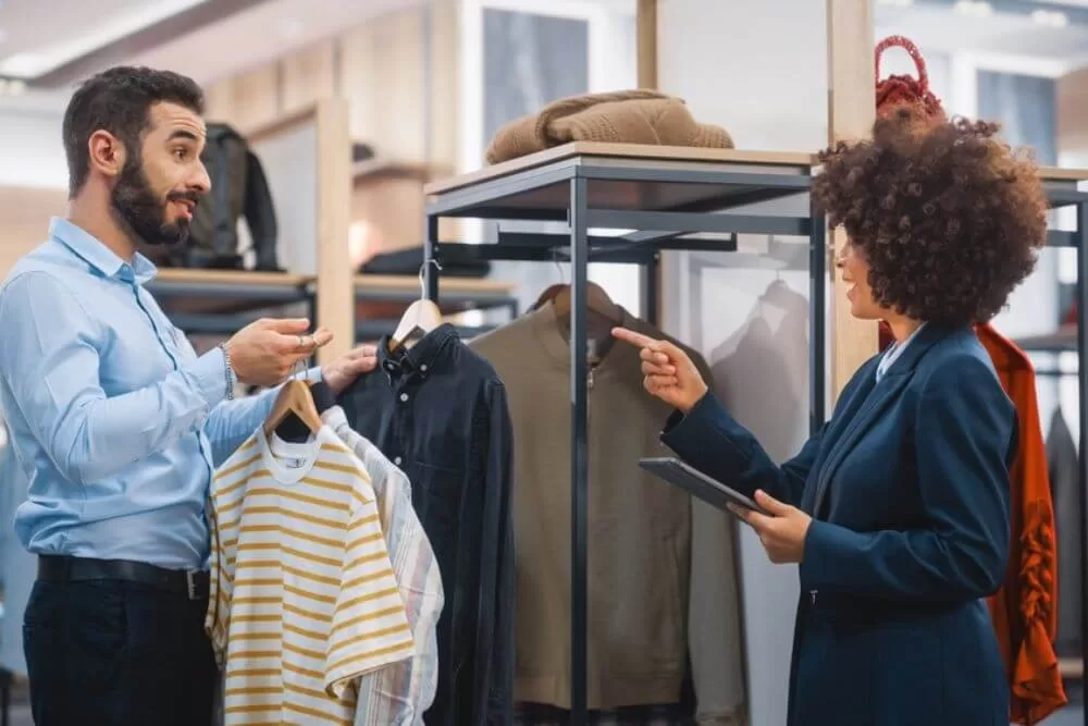 atendente conversando com cliente em loja de roupa